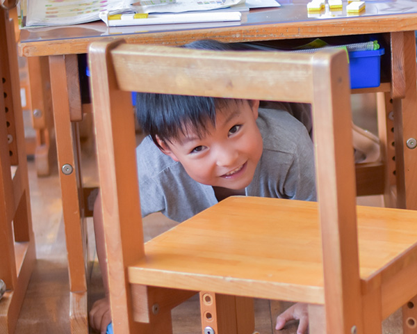 授業中に椅子の下に隠れる小学生の画像